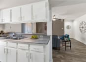 Thumbnail 22 of 36 - a kitchen and living room with white cabinets and a sink  at Glen Brae, Glendale, 85301