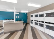 Thumbnail 13 of 36 - a kitchen with white cabinets and a counter and a blue wall at Glen Brae, Glendale