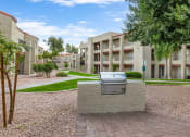 Thumbnail 8 of 36 - an outdoor area with a grill in front of an apartment building at Glen Brae, Arizona