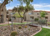 Thumbnail 32 of 36 - an apartment building with a courtyard with cactus and rocks at Glen Brae, Arizona