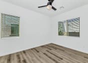 Thumbnail 36 of 81 - A room with a ceiling fan and two windows with blinds at Marketside Villas at Verrado, Buckeye, AZ