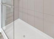 Thumbnail 38 of 81 - A white bathtub with a shower door in a bathroom at Marketside Villas at Verrado, Buckeye, AZ