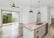 Thumbnail 56 of 81 - A modern kitchen with a marble countertop and wooden flooring at Marketside Villas at Verrado, Buckeye, AZ