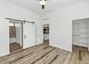 Thumbnail 59 of 81 - A room with white walls and wooden flooring, featuring a sliding door and a bar shelf at Marketside Villas at Verrado, Buckeye, AZ
