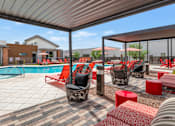 Thumbnail 74 of 81 - A poolside area with red and black furniture at Marketside Villas at Verrado, Buckeye, AZ