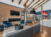 Thumbnail 8 of 81 - A modern living room with a fireplace and a grey sofa at Marketside Villas at Verrado, Buckeye, AZ