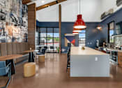 Thumbnail 6 of 81 - A modern kitchen with a dining area and a large painting on the wall at Marketside Villas at Verrado, Buckeye, AZ