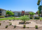 Thumbnail 12 of 34 - A courtyard with a circular garden in the middle surrounded by apartment buildings at Reflections at Red Mountain Apartments, Mesa