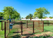 Thumbnail 15 of 34 - A fenced area with a trash can and trees in the background at Reflections at Red Mountain Apartments, Arizona, 85213