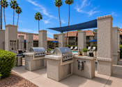 Thumbnail 7 of 20 - A row of outdoor BBQs are lined up under a blue shade sail.