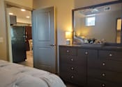 Thumbnail 14 of 14 - Bedroom with dresser and view to kitchen at Pinon Lofts Apartments, Arizona