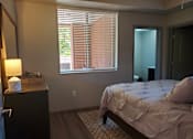 Thumbnail 13 of 14 - Bedroom with ensuite bathroom and wood flooring at Pinon Lofts Apartments, Arizona, 86336