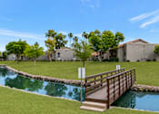 Thumbnail 10 of 20 - A small bridge over a pond in a residential area.