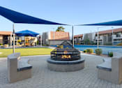 Thumbnail 45 of 54 - A fire pit is surrounded by two concrete benches under a blue canopy at Denim Scottsdale, Scottsdale, AZ