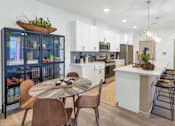 Thumbnail 14 of 54 - A modern kitchen with a dining table and chairs.