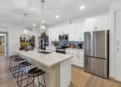 Thumbnail 16 of 54 - A modern kitchen with a white island and stainless steel appliances.