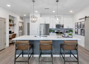 Thumbnail 2 of 54 - A kitchen with a white countertop and brown barstools.