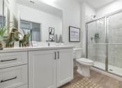 Thumbnail 25 of 54 - A white bathroom with a toilet, sink, and mirror.