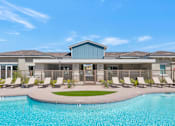 Thumbnail 30 of 54 - A swimming pool in front of a building with a blue sky in the background.