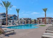 Thumbnail 31 of 54 - A pool surrounded by palm trees and sun loungers.