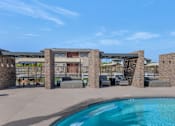Thumbnail 32 of 54 - A pool surrounded by stone pillars and a building in the background.