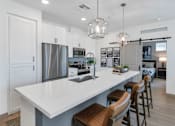 Thumbnail 4 of 54 - A modern kitchen with a large island and stools.