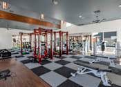 Thumbnail 41 of 54 - A gym with a variety of equipment including treadmills, stationary bikes, and weight machines.