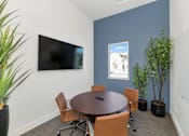 Thumbnail 46 of 54 - A conference room with a table, chairs, and a television.