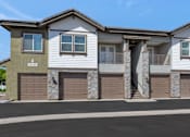 Thumbnail 50 of 54 - A modern two-story house with stone pillars and garage doors.
