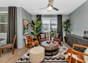 Thumbnail 6 of 54 - A living room with a rug, a coffee table, a chair, a sofa, a ceiling fan, and a plant.