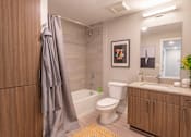Thumbnail 24 of 52 - A bathroom with a toilet, sink, and a shower curtain.