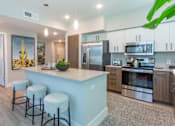 Thumbnail 16 of 52 - A kitchen with a bar area and stools.