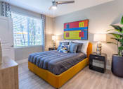 Thumbnail 22 of 52 - A bedroom with a bed, nightstand, and a painting on the wall.