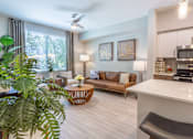 Thumbnail 11 of 52 - A living room with a brown sofa and a white counter.