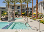 Thumbnail 3 of 52 - A swimming pool surrounded by palm trees and yellow umbrellas.