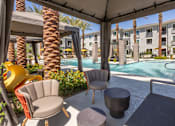 Thumbnail 29 of 52 - A patio with a table and chairs overlooking a pool.