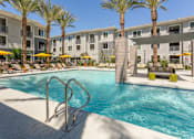Thumbnail 2 of 52 - A swimming pool surrounded by palm trees and lounge chairs.