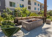 Thumbnail 32 of 52 - A patio with a fire pit and chairs.