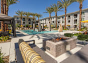Thumbnail 31 of 52 - A pool area with a fire pit and lounge chairs.