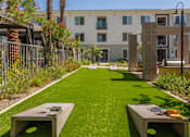 Thumbnail 34 of 52 - A grassy area with two concrete benches in front of a building.