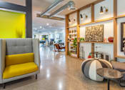 Thumbnail 47 of 52 - A yellow chair is in the foreground of a modern room.