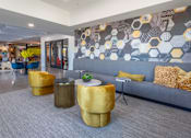 Thumbnail 38 of 52 - A modern living room with a grey couch and a grey and yellow patterned wallpaper.