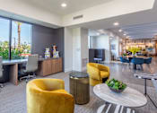 Thumbnail 50 of 52 - A modern office space with yellow chairs and a large window overlooking a palm tree.