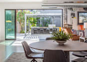 Thumbnail 44 of 52 - A modern dining room with a table and chairs.
