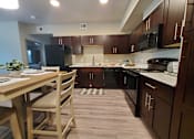 Thumbnail 5 of 14 - Modern kitchen with dark wood cabinets at Pinon Lofts Apartments, Sedona, AZ 86336