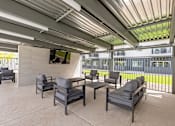 Thumbnail 7 of 26 - Outdoor lounge area with adjustable shade pergola at Lucero Apartments, Phoenix, AZ 85051