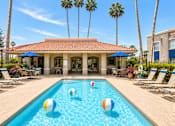 Thumbnail 4 of 20 - A pool with a house and palm trees in the background.