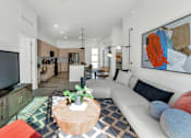 Thumbnail 16 of 35 - A living room with a white couch and a television on a wooden stand.at Marketside Villas at Verrado, Arizona, 85396