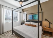 Thumbnail 17 of 35 - A bedroom with a four poster bed and a ceiling fan.at Marketside Villas at Verrado, Buckeye, AZ