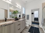 Thumbnail 19 of 35 - A bathroom with a sink, mirror, toilet, and a chair.at Marketside Villas at Verrado, Buckeye